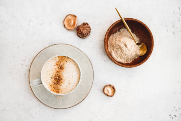 widok z góry grzyb latte z shiitake proszku i niesłodzone mleko kokosowo-migdałowe mieszanki. zdrowy użyteczny wegański napój, płaski leżał. - powdered coconut zdjęcia i obrazy z banku zdjęć