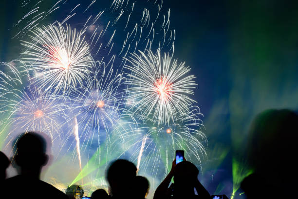 istock Crowd watching fireworks and celebrating city founded. Beautiful colorful fireworks display in the urban for celebration on dark night background. 1159824214