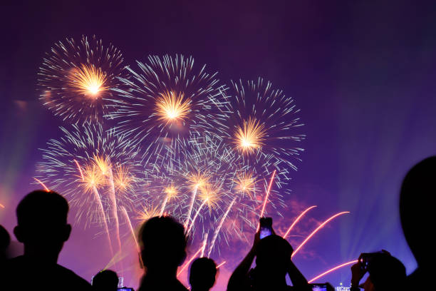 istock Crowd watching fireworks and celebrating city founded. Beautiful colorful fireworks display in the urban for celebration on dark night background. 1159824216