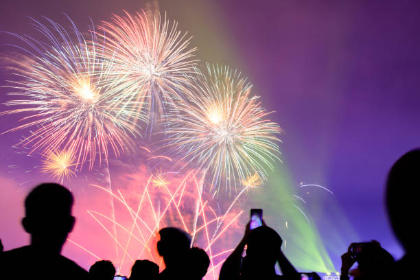 istock Crowd watching fireworks and celebrating city founded. Beautiful colorful fireworks display in the urban for celebration on dark night background. 1159824247