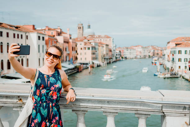 istock Young woman using smartphone in Venice, Italy 1159824962
