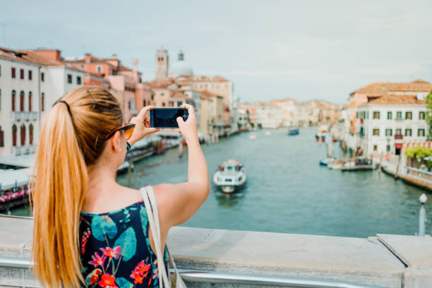 istock Young woman using smartphone in Venice, Italy 1159824963