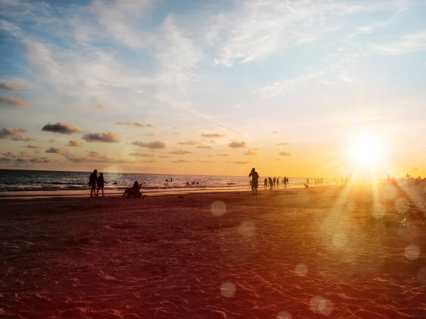 istock group of silhouetted people on public beach over orange colored sunset sky 1159827342