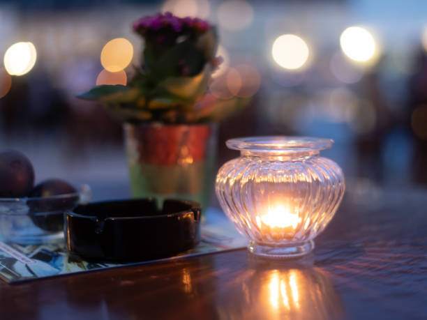 istock wooden table with ashtray and plant illuminated by romantic candle light 1159827601