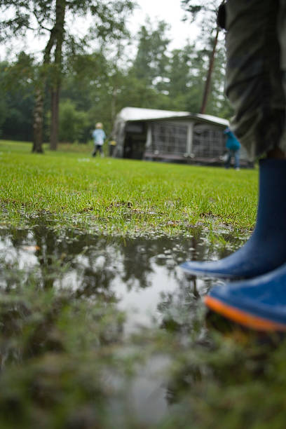 kind mit blauen stiefel stehen in einen pool von wasser - camping mobile home vacations tent stock-fotos und bilder