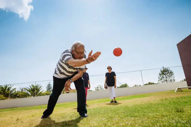 Outdoor activity for vital seniors - Hispanic seniors playing boules in summer. Image with lots of copy space.