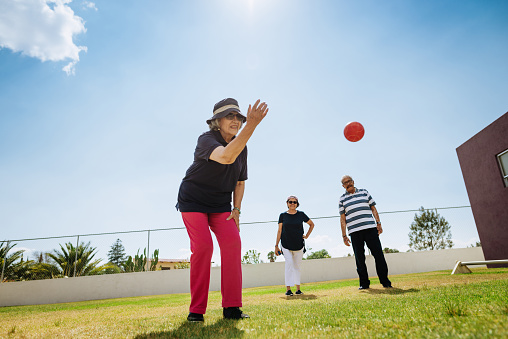 Outdoor activity for vital seniors - Hispanic seniors playing boules in summer. Image with lots of copy space.