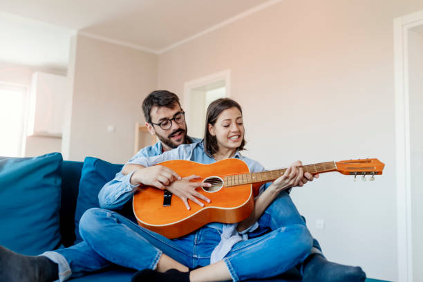 istock Man Teaching His Girlfriend to Play Guitar 1159830743