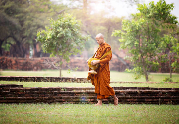 istock Full Length Of Monk Walking With Urn On Grass 1159834625