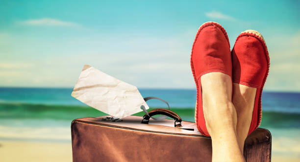 istock Legs with red cloth shoes in front of beach 1159835021