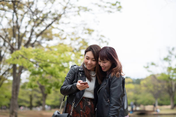 istock Female couple watching smart phone together 1159837236