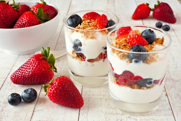 erdbeere und heidelbeere perfekt vor weißem holzhintergrund - yogurt stock-fotos und bilder