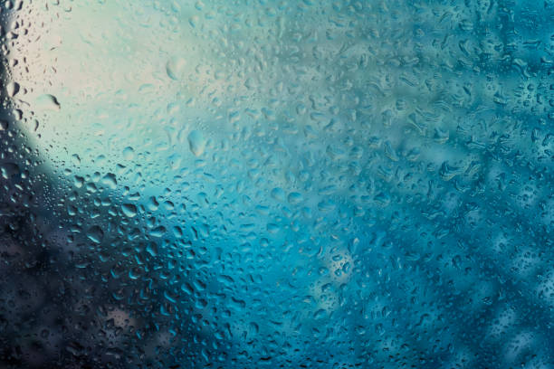 Neon lights behind water drops close up