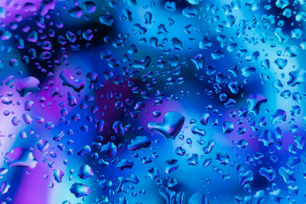 Neon lights behind water drops close up