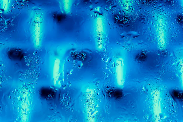 Neon lights behind water drops close up