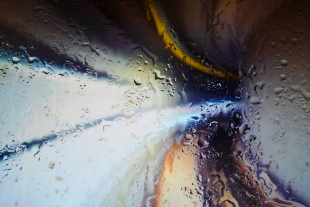 Neon lights behind water drops close up