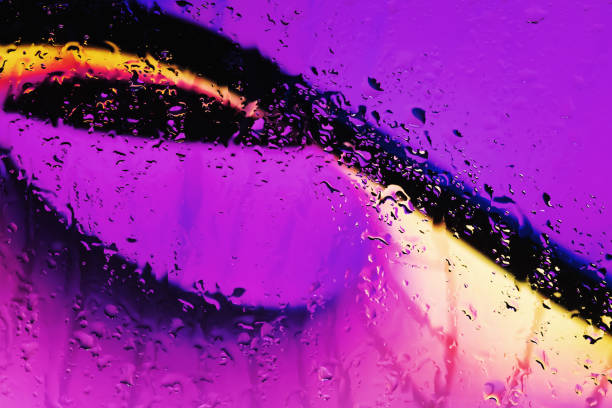 Neon lights behind water drops close up