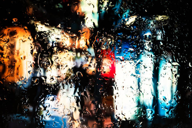 Neon lights behind water drops close up