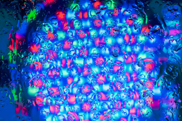 Neon lights behind water drops close up