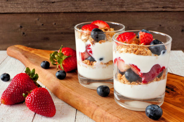 istock Strawberry and blueberry parfaits on a serving board against a dark background 1159840000