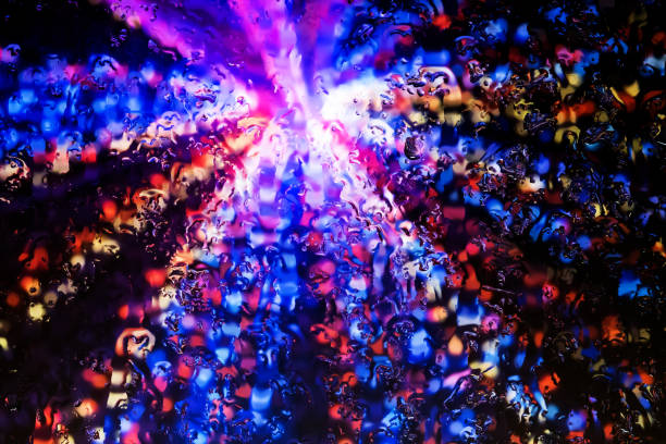 Neon lights behind water drops close up
