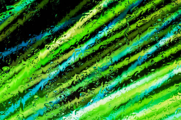 Neon lights behind water drops close up