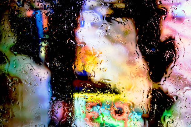 Neon lights behind water drops close up