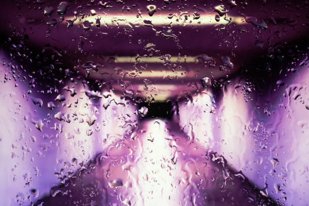 Neon lights behind water drops close up