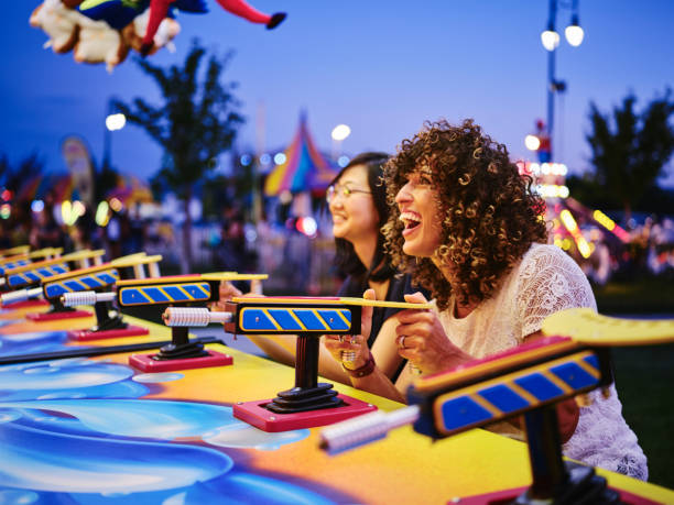 Summer Fun Carnival Games Two young women having fun and playing games at a summer carnival midway. traveling carnival photos stock pictures, royalty-free photos & images
