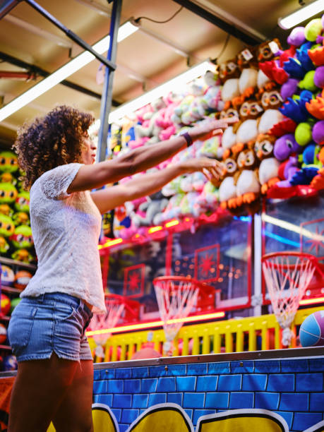 Summer Fun Carnival Games A young woman having fun and playing games at a summer carnival midway. midway fair stock pictures, royalty-free photos & images