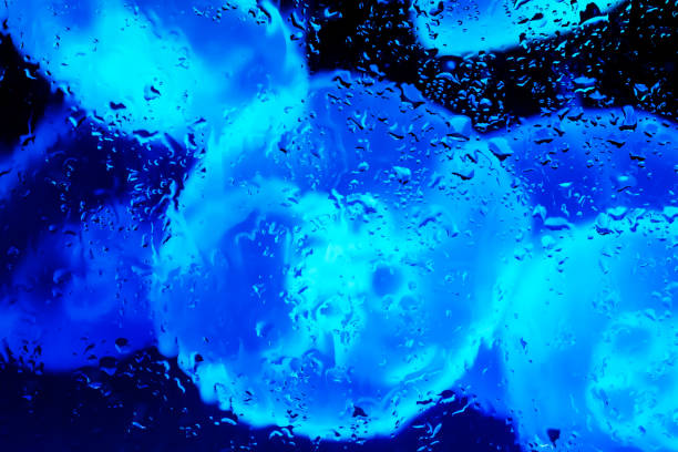 Neon lights behind water drops close up