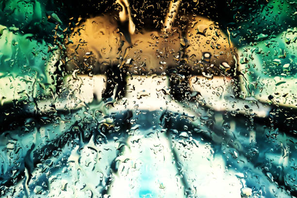 Neon lights behind water drops close up
