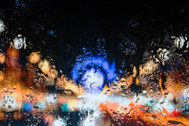 Neon lights behind water drops close up