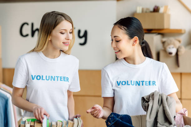 istock two attractive multicultural volunteers unpacking carton boxes with books and clothes 1159843835