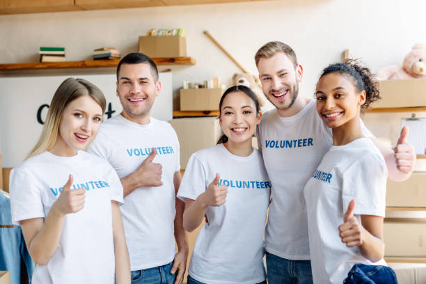 istock five young multicultural volunteers showing thumbs up, smiling and looking at camera 1159843854