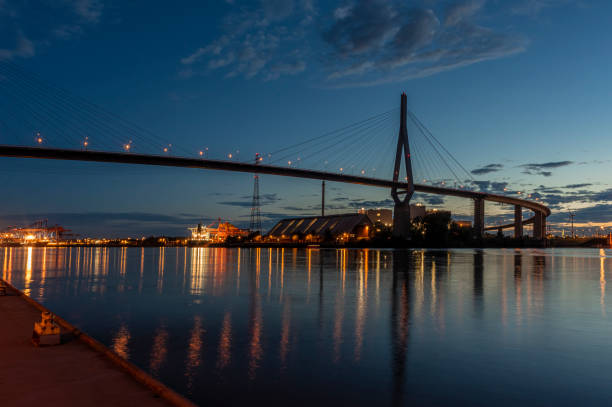 Köhlbrand Bridge in the Blue Hour The Köhlbrand Bridge in Hamburg over the Elbe after sunset. In the background the lights and ships in the container terminal. köhlbrandbrücke stock pictures, royalty-free photos & images
