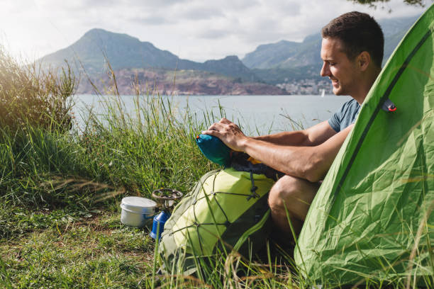 istock Handsome traveler packing his backpack from his tent 1159845172