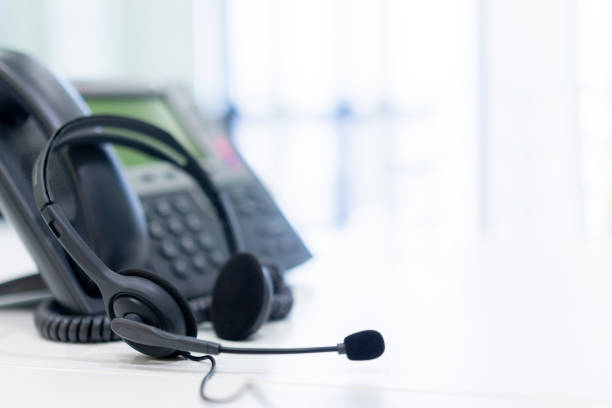 istock close up headset of call center and VOIP for communication technology on office table  in monitoring room for network operation job concept 1159845241