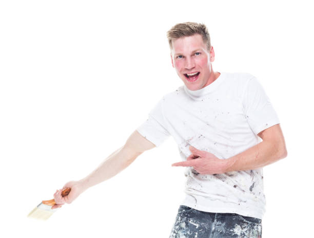 istock Young male painter with stained clothes on white background - looking at camera, showing to the back 1159845621