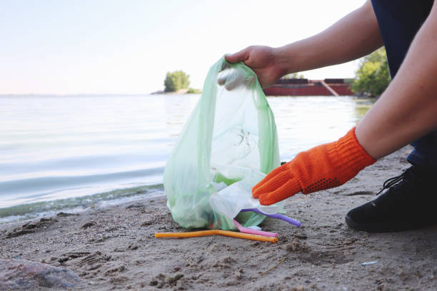 istock Garbage collection on the beach. Plastic and packages scattered on the beach. A man collects plastic. Ecology protection concept 1159848666