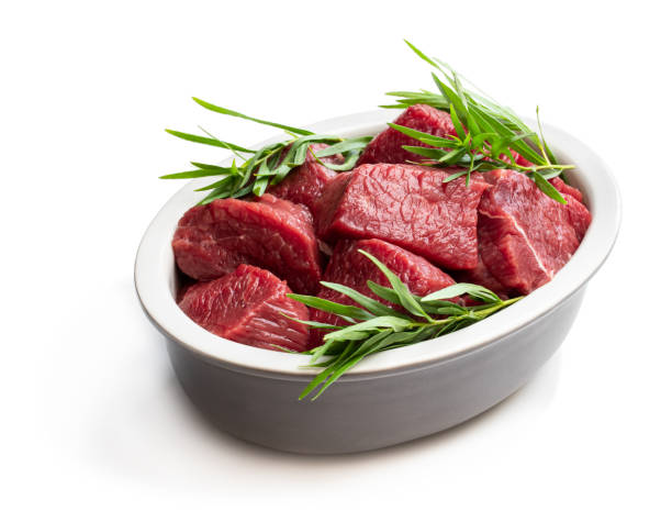 istock Sliced raw beef with tarragon herb in ceramic bowl isolated on white 1159848759