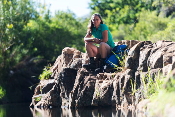 istock Happy woman sitting at the water's edge 1159849024
