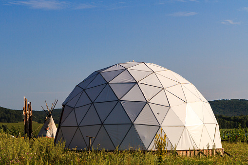 white geodesic dome on a sunny summer day in nature.