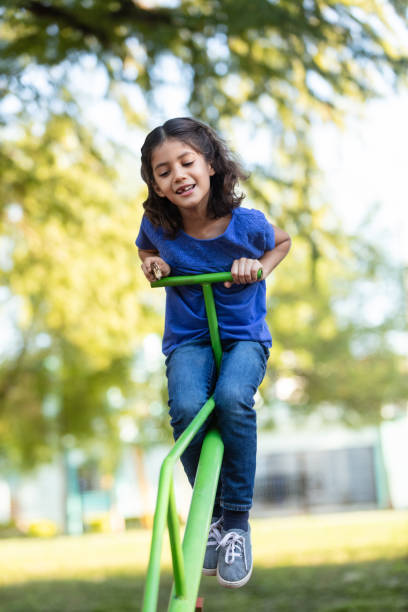 istock Pretty girl on a seesaw 1159851698