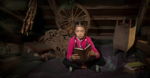 istock Girl in the attic reading an old book. 1159852635