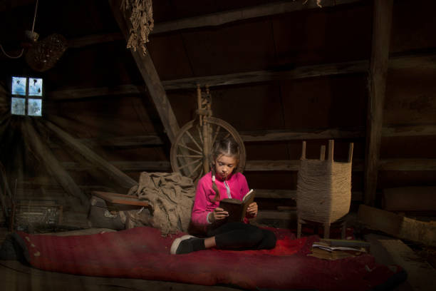 istock Girl in the attic reading an old book. 1159852636