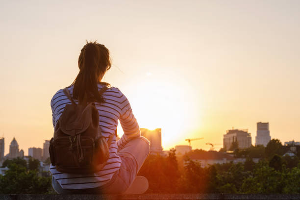 Concept hope the best. Concept hope the best. Woman sitting on a background of a sunset over the city. town of hope stock pictures, royalty-free photos & images