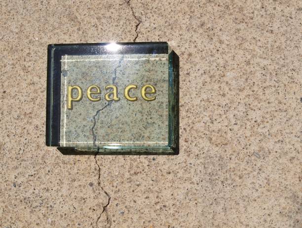istock “Peace” written on a clear block overlies a crack in concrete 1159856954