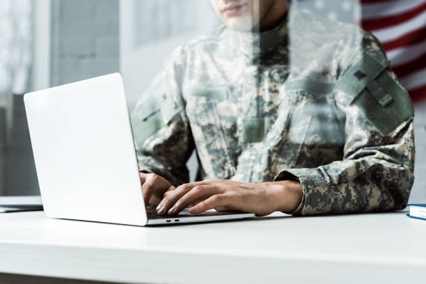 vista cortada do soldado no uniforme camuflar usando o portátil - military technology - fotografias e filmes do acervo