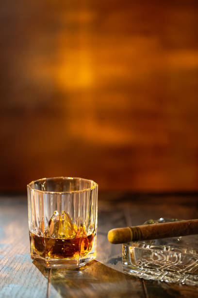 whisky con ghiaccio e sigaro su sfondo legnoso - cigar whisky bar cognac foto e immagini stock